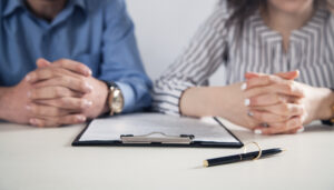 Couple with divorce contract and ring on desk. Divorce